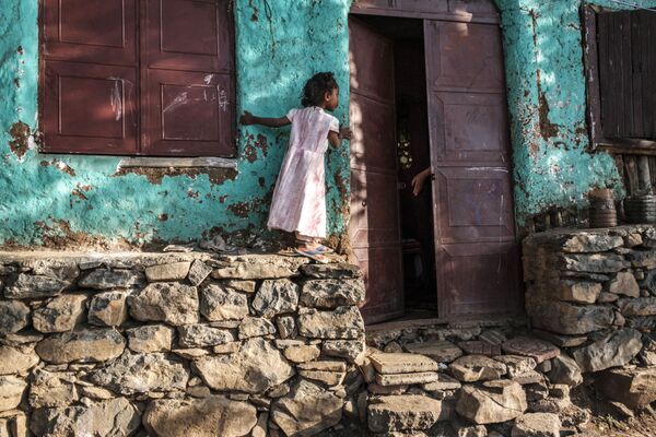 Девочка заглядывает в приоткрытую дверь в городе Гондар, Эфиопия - Sputnik Азербайджан