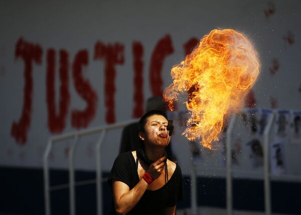 Активистка плюет огненными шарами во время акции протеста перед зданием Генеральной прокуратуры в Мехико, Мексика - Sputnik Азербайджан