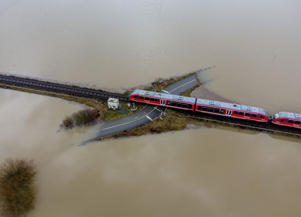 Так в феврале 2021 года выглядел железнодорожный переезд Ниддерау недалеко от Франкфурта. Причина наводнения в Германии - тающие снега и затяжные дожди. - Sputnik Азербайджан