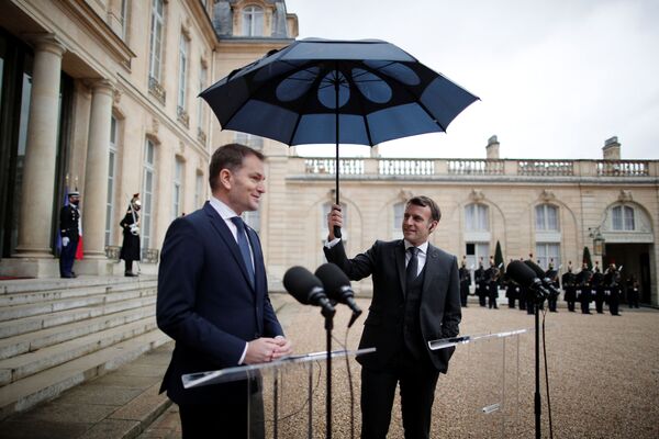 Президент Франции Эммануэль Макрон держит зонтик рядом с премьер-министром Словакии Игорем Матовичем во время совместного заявления в Елисейском дворце в Париже - Sputnik Azərbaycan