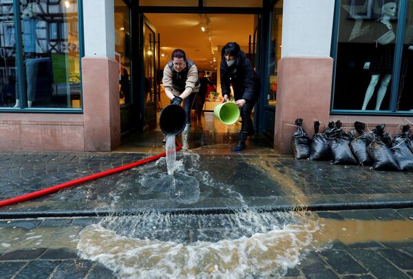 Сотрудницы магазина одежды во Франкфурте ликвидируют последствия наводнения - Sputnik Азербайджан