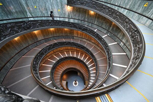 Мужчина спускается по лестнице Браманте в музее Ватикана - Sputnik Азербайджан