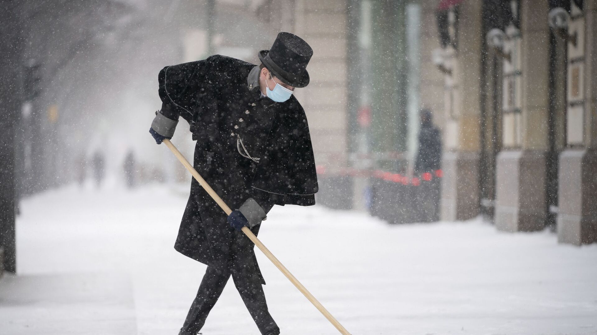 Сотрудник отеля Adlon чистит тротуар от снега на Парижской площади в Берлине - Sputnik Азербайджан, 1920, 15.11.2023