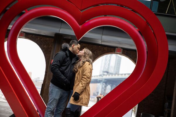 Анджелина Сардж и Ричард Рубидо целуются перед скульптурой сердца в DUMBO в День святого Валентина в Нью-Йорке - Sputnik Azərbaycan