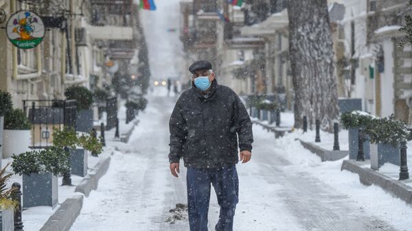 Мужчина во время снежной погоды в Баку, фото из архива - Sputnik Азербайджан