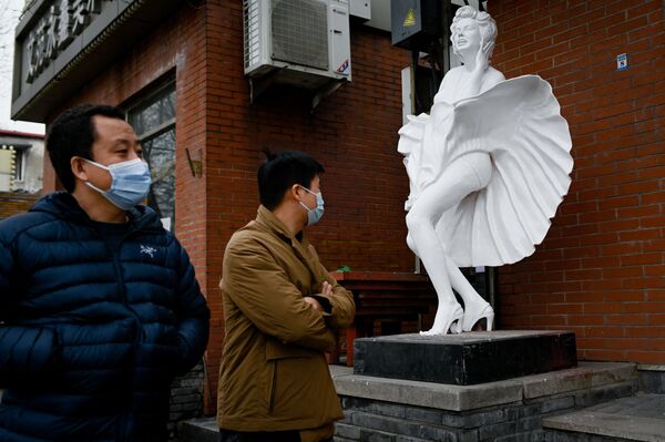 Прохожие у статуи возле магазина на улице в Пекине - Sputnik Azərbaycan