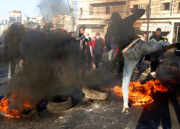 Демонстранты блокируют дорогу горящими шинами во время акции протеста против падения курса ливанского фунта, в Сидоне, Ливан - Sputnik Азербайджан