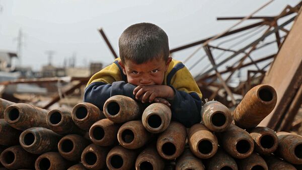 Ребенок на куче нейтрализованных снарядов на свалке металлолома города Маарет-Мисрин в  провинции Идлиб, Сирия - Sputnik Азербайджан
