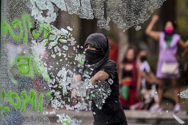 Женщина разбивает стекло в ходе посвященной Международному женскому дню демонстрации в Мехико, Мексика - Sputnik Азербайджан