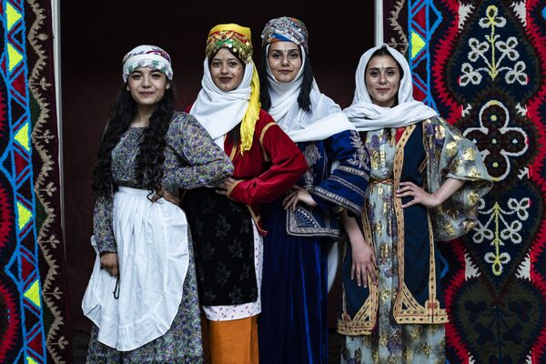 Сирийские курдские женщины в традиционной одежде позируют фотографу во время ежегодной церемонии празднования Дня курдской одежды в городе Камишли - Sputnik Azərbaycan