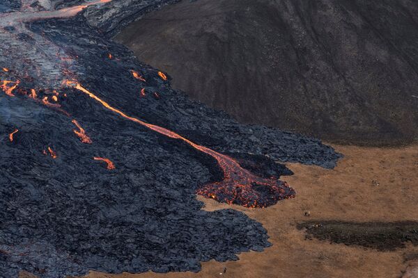 Потоки лавы во время извержения вулкана на полуострове Рейкьянес в Исландии - Sputnik Azərbaycan