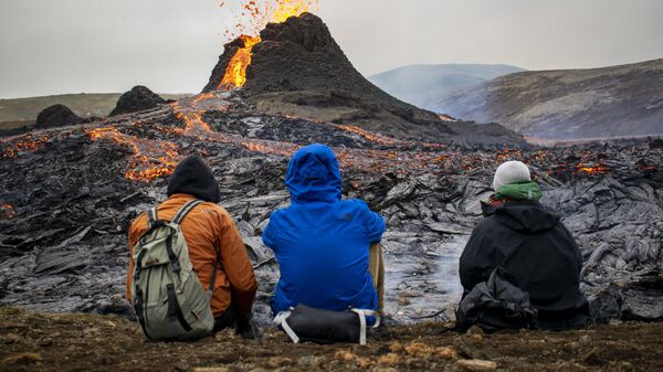 Туристы наблюдают за извержением вулкана на полуострове Рейкьянес в Исландии - Sputnik Азербайджан
