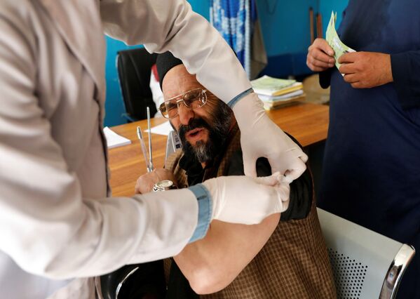 Работник больницы во время вакцинации AstraZeneca в Кабуле, Афганистан  - Sputnik Азербайджан
