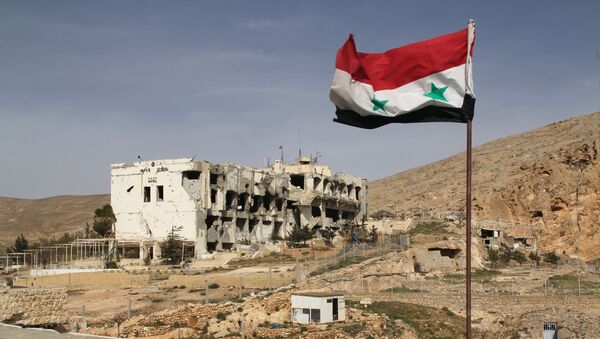 Сирийский флаг на фоне разрушенного дома в сирийском городе Маалюля - Sputnik Азербайджан
