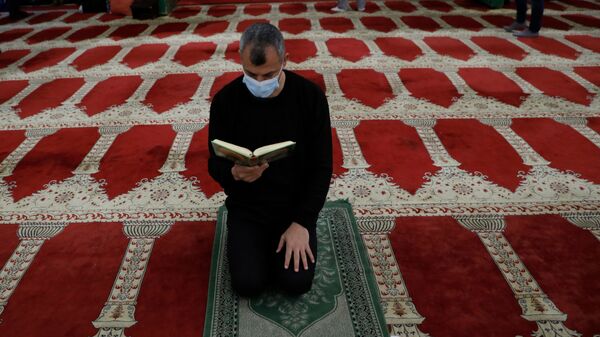 Мужчина читает Коран, фото из архива - Sputnik Azərbaycan