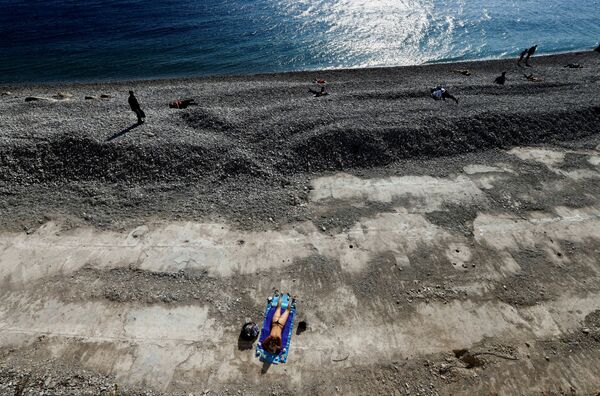Женщина загорает на пляже в Ницце во время третьего локдауна во Франции - Sputnik Азербайджан