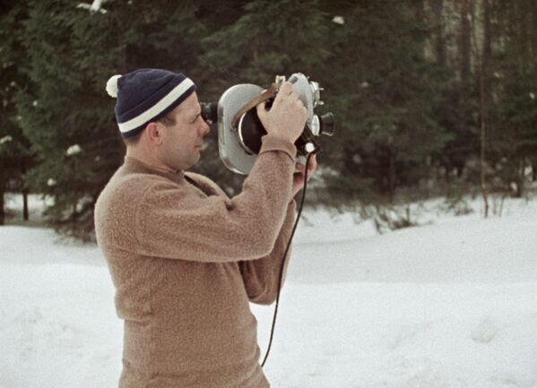 Летчик-космонавт Юрий Гагарин c кинокамерой в зимнем лесу, 1965 год - Sputnik Азербайджан