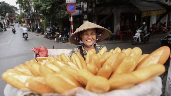 Уличная торговка с багетами на одной из улиц Ханоя, Вьетнам - Sputnik Азербайджан