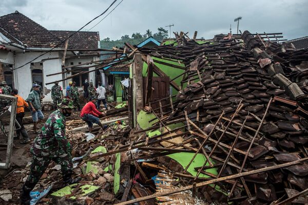 Индонезийские солдаты и местные жители проверяют поврежденные землетрясением дома в Маланге - Sputnik Азербайджан