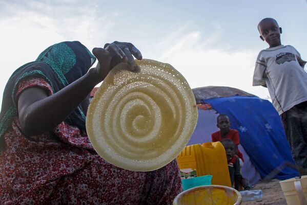 Сомалийская женщина во время приготовления блинов в Могадишо  - Sputnik Азербайджан