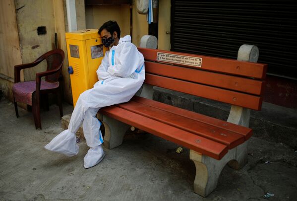 Обессиленный медицинский работник отдыхает в крематории в Нью-Дели, Индия - Sputnik Азербайджан