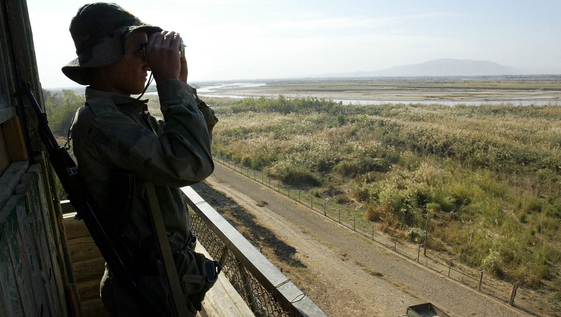Солдат таджикской пограничной службы патрулирует реку Пяндж на границе с Афганистаном в 220 км от Душанбе - Sputnik Азербайджан, 1920, 06.06.2021