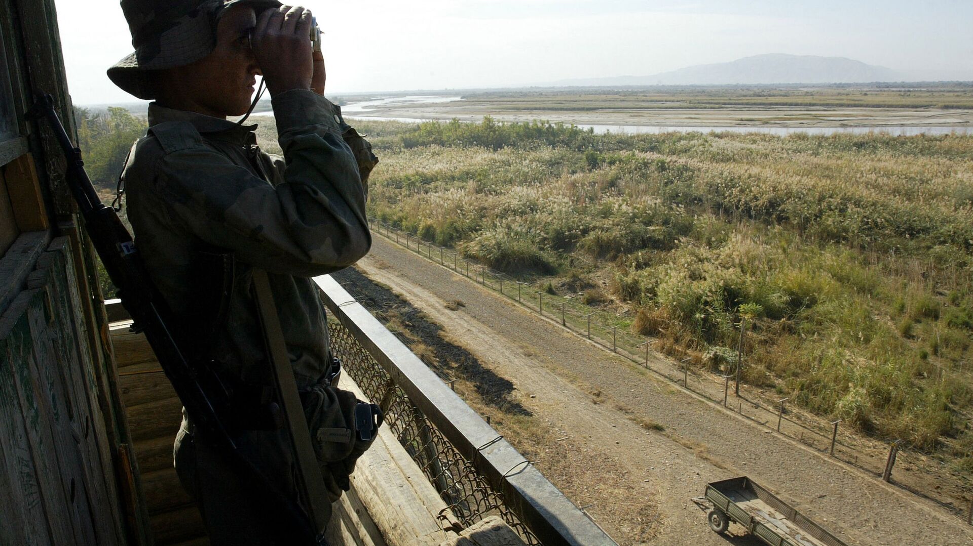 Солдат таджикской пограничной службы патрулирует реку Пяндж на границе с Афганистаном в 220 км от Душанбе - Sputnik Азербайджан, 1920, 01.05.2021