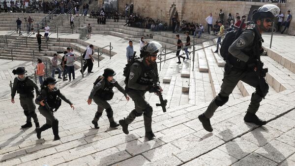 Сотрудники израильской полиции во время столкновений с палестинцами возле мечети Аль-Акса в Иерусалиме - Sputnik Азербайджан