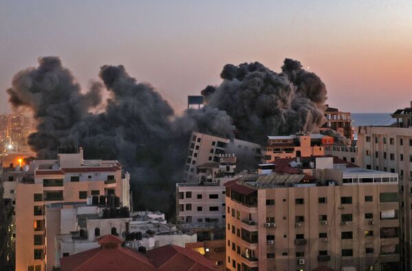 Пожарные тушат горящие многоквартирные дома после израильских авиаударов в городе Газа - Sputnik Azərbaycan