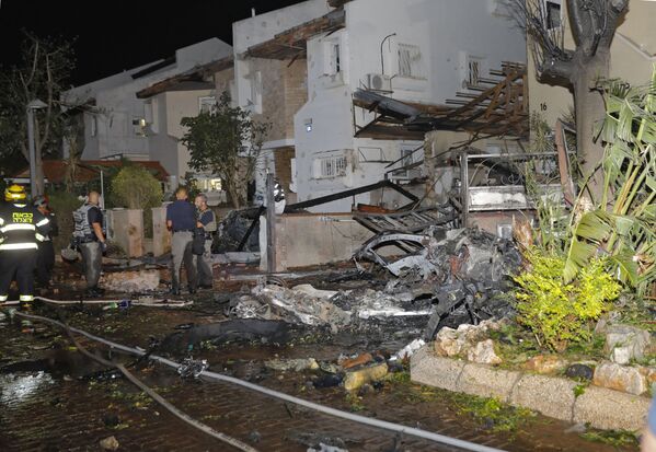 Члены израильской аварийной службы осматривают повреждения в израильском городе Ришон-ле-Цион - Sputnik Азербайджан