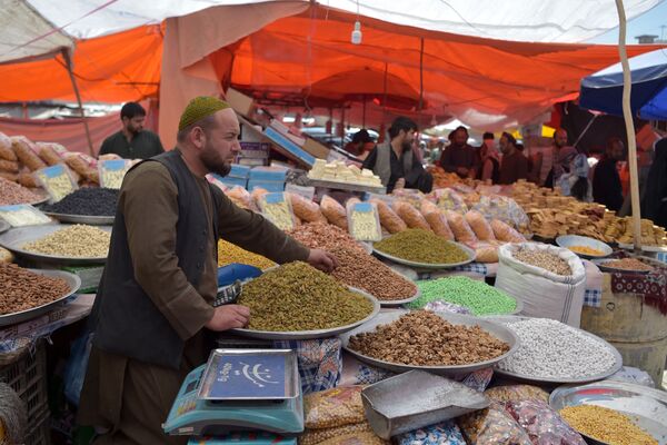 Продавец ждет покупателей у своего ларька с сухофруктами и печеньем в преддверии праздника Ид аль-Фитр на рынке в Кабуле - Sputnik Azərbaycan