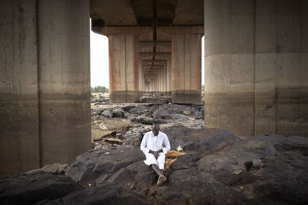  Мужчина медитирует под третьим мостом Бамако во время Ид-аль-Фитр - Sputnik Azərbaycan