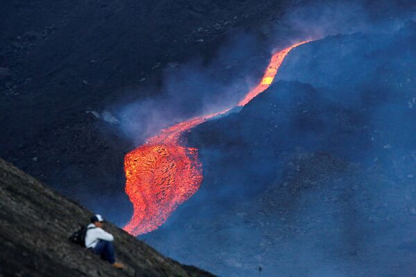 Мужчина наблюдает за течением раскаленной лавы вулкана Пакая в регионе Эскуинтла, Гватемала - Sputnik Azərbaycan