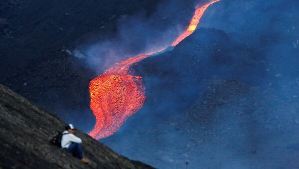 Мужчина наблюдает за течением раскаленной лавы вулкана Пакая в регионе Эскуинтла, Гватемала - Sputnik Азербайджан