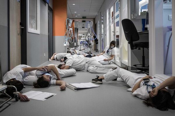 Медсестры и медперсонал лежат на полу в отделении интенсивной терапии во время демонстрации в Международный день медсестер и ухода в больнице Mont Legia в Льеже, Бельгия - Sputnik Azərbaycan