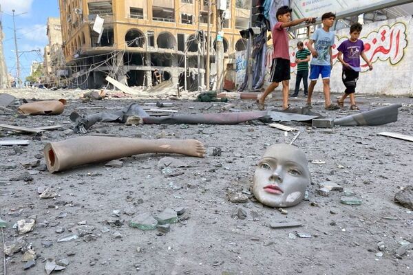Части сломанного манекена лежат на земле возле здания, пострадавшего от ударов израильской авиации во время вспышки израильско-палестинского конфликта, Газа - Sputnik Azərbaycan