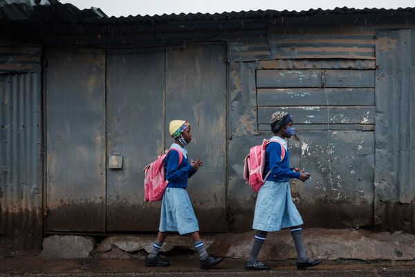 Ученицы идут в олимпийскую начальную школу после 6-недельного перерыва, связанного с коронавирусом, в трущобах Киберы, Найроби - Sputnik Azərbaycan
