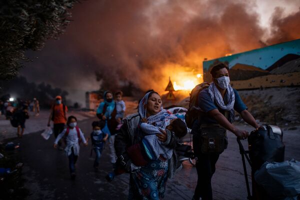 Снимок из серии Fleeing a Fire Burning Refugee Camp греческого фотографа Petrosa Giannakouris, ставшим третьим в категории Single News конкурса Istanbul Photo Awards 2021 - Sputnik Азербайджан
