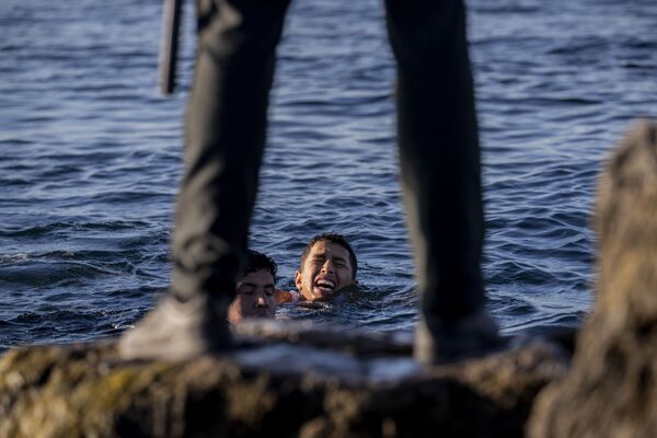 Представитель Испанской гражданской гвардии ожидает мигрантов на берегу в испанском анклаве Сеута, недалеко от границы Марокко и Испании - Sputnik Azərbaycan