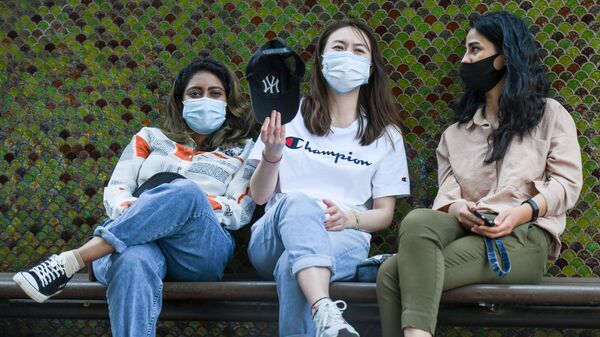 Девушки в медицинских масках сидят на скамейке в Баку, фото из архива - Sputnik Азербайджан