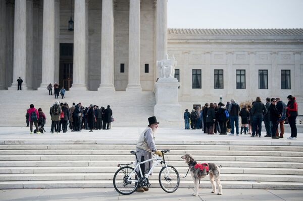 Мужчина с велосипедом и собакой у здании суда в Вашингтоне  - Sputnik Azərbaycan