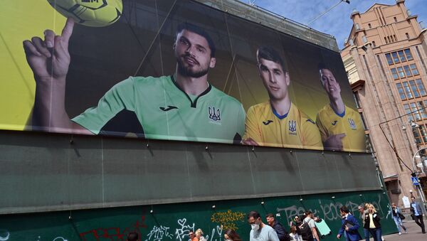 Прохожие проходят мимо рекламного щита с изображением игроков сборной Украины по футболу в Киеве. 7 июня 2021 года - Sputnik Азербайджан