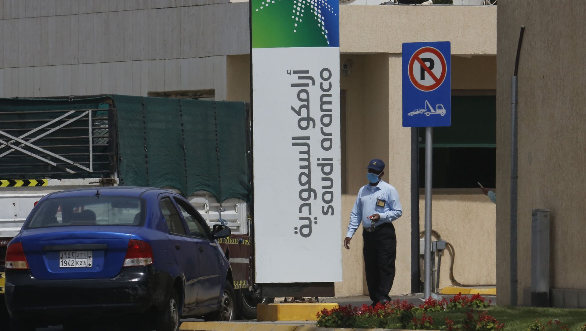 Сотрудник службы безопасности в маске проверяет автомобиль, въезжающий на территорию комплекса Saudi Aramco в Джидде, Саудовская Аравия, в понедельник, 9 марта 2020 года - Sputnik Azərbaycan, 1920, 11.06.2021