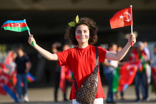 Девушка с флагами Азербайджана и Турции рядом с Бакинским олимпийским стадионом перед началам матча второго тура группового этапа ЕВРО-2020 Турция-Уэльс - Sputnik Азербайджан