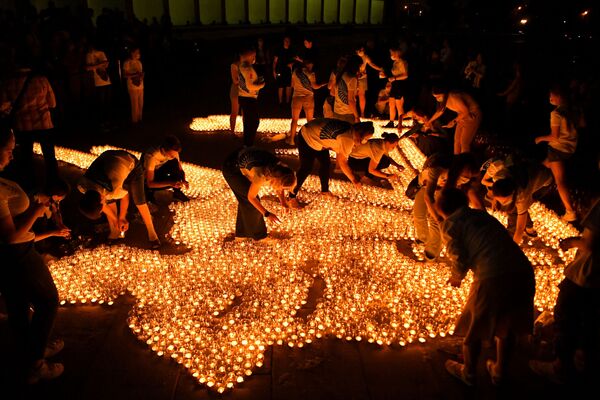 Участники акции Свеча памяти зажигают свечи перед Музеем Победы в Москве - Sputnik Azərbaycan