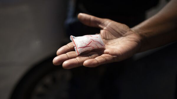 Офицер правоохранительных органов держит пакет с метамфетамином, фото из архива - Sputnik Azərbaycan