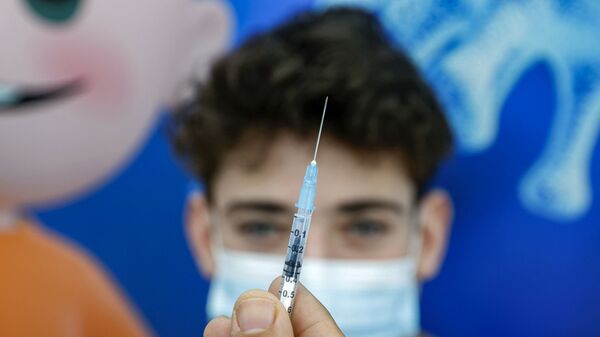 Мальчик получает дозу вакцины от коронавируса, фото из архива - Sputnik Азербайджан