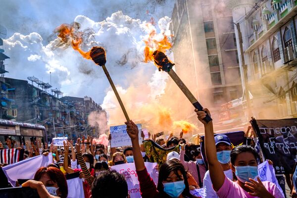 Женщины несут горящие факелы во время демонстрации против военного переворота в Янгоне  - Sputnik Азербайджан