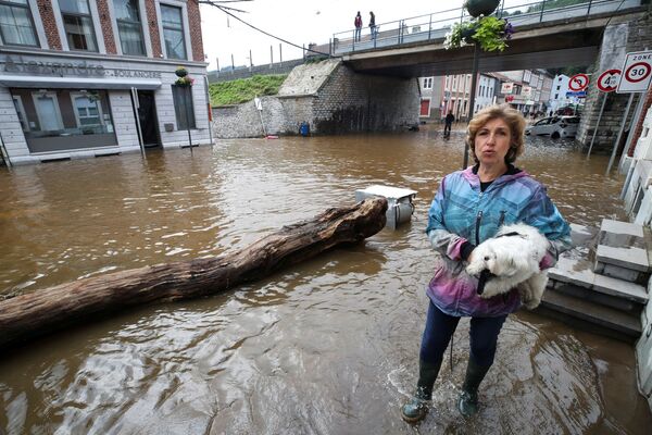 Женщина с собакой на территории, пострадавшей от наводнения после проливных дождей, в Пепинстере, Бельгия. - Sputnik Азербайджан