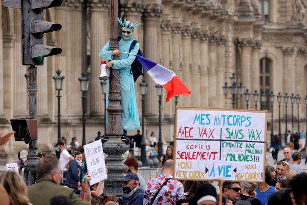 Демонстрант в костюме статуи Свободы принимает участие в акции протеста против объявленных президентом Франции Эммануэлем Макроном новых мер по борьбе со вспышкой коронавируса в Париже, Франция - Sputnik Азербайджан